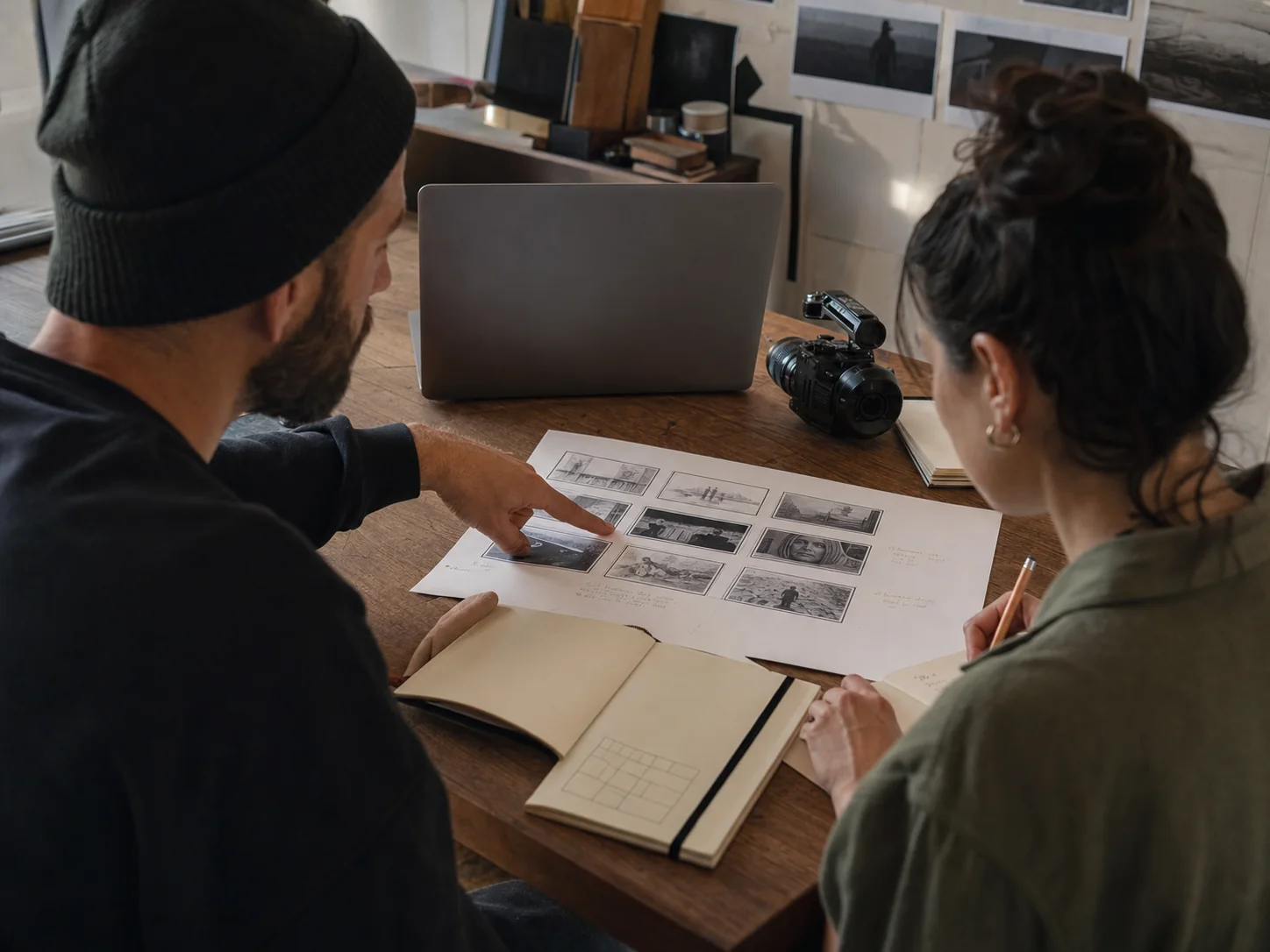 Two creative collaborators reviewing a video storyboard at a studio desk